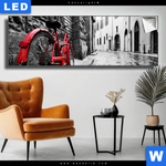 Leuchtbild Rotes Fahrrad In Gasse Panorama Produktvorschau mit dem Bild Rotes Fahrrad in Gasse im Format Panorama.