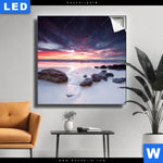 Leuchtbild Sonnenaufgang Am Strand Mit Felsen Quadrat Produktvorschau mit dem Bild Sonnenaufgang am Strand mit Felsen im Format Quadrat.