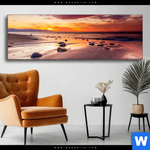Wechselmotiv Sonnenuntergang Am Strand Mit Felsen Panorama Produktvorschau mit dem Bild Sonnenuntergang am Strand mit Felsen im Format Panorama.